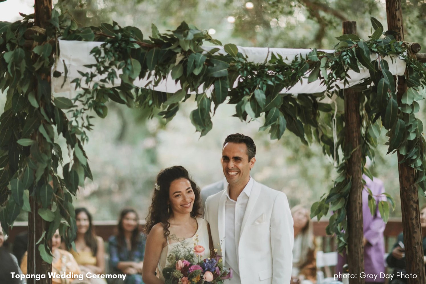 Couple beneath a floral arch, Topanga wedding ceremony by Kilkea Design